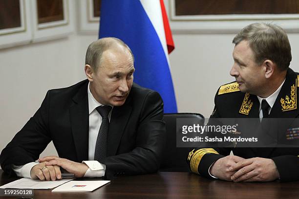 Russian President Vladimir Putin listens to Adm. Viktor Chirkov as he visits the heavy nuclear-powered missile cruiser Pyotr Veliky at the Russian...