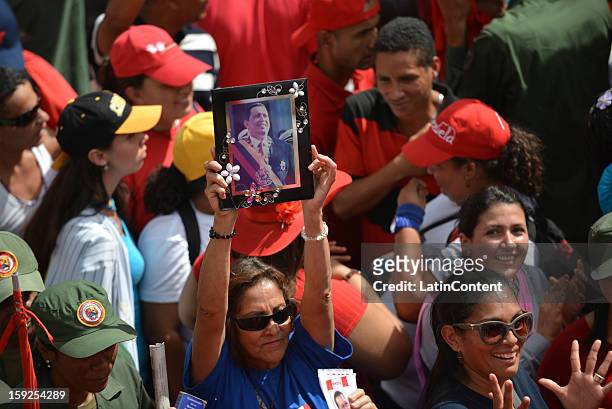 Woman holds a picture of Hugo Chavez while supporters of the Venezuelan President gather around Miraflores Presidential Palace on January 10, 2013 in...