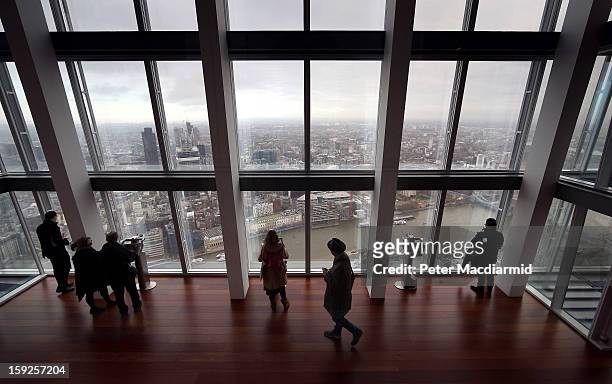 Visitors look out from the Shard viewing platform on January 9, 2013 in London, England. Standing at 309.6 metres high, the Shard is open to the...