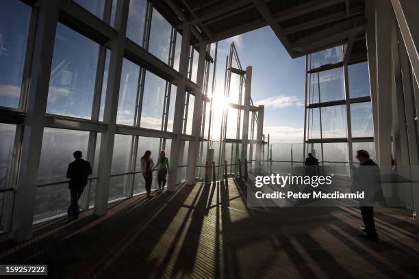 Visitors look out from the Shard viewing platform on January 9, 2013 in London, England. Standing at 309.6 metres high, the Shard is open to the...