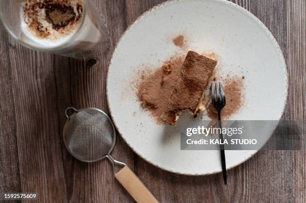 tiramisu with a fork and a strainer - chocolate powder stock-fotos und bilder