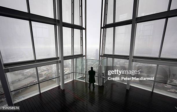 Security guard looks out from the Shard viewing platform on January 9, 2013 in London, England. Standing at 309.6 metres high, the Shard is open to...