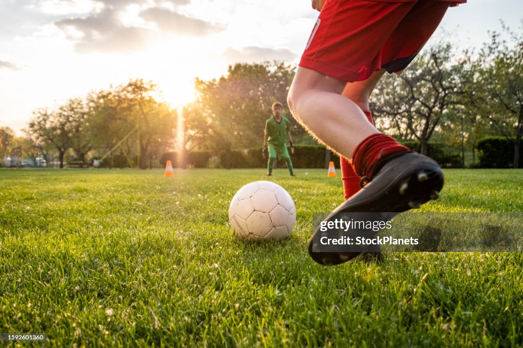 The boy prevents the ball from entering the goal