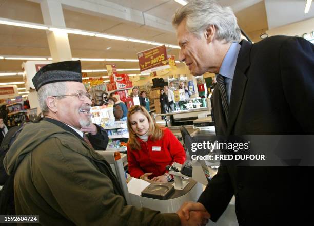 Le ministre de l'Interieur Dominique de Villepin salue, le 14 février 2005 à Lyon, le client d'un supermarché à l'occasion d'une visite sur le thème...