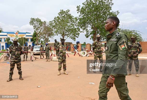 Nigerien soldiers stand guard as supporters of Niger's National Council for the Safeguard of the Homeland gather for a demonstration in Niamey on...