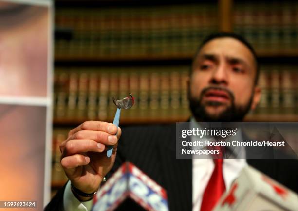 Attorney Muhammad Aziz holds up a piece of shrapnel from a malfunctioning Takata airbag he says hit his client Serena Martinez in a minor crash in...