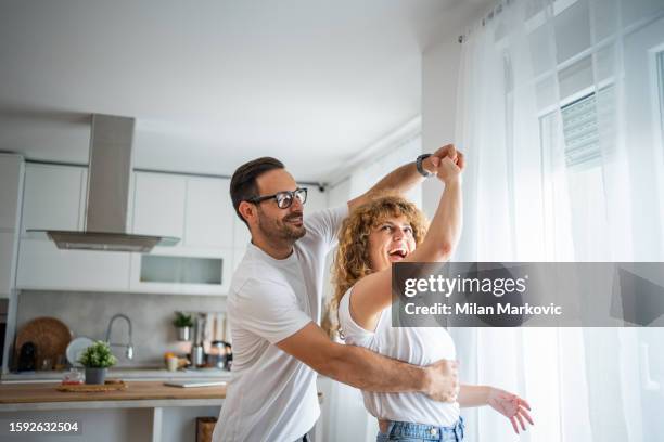 a wonderful scene of love and happiness between a couple in love enjoying their new apartment - young couple dancing stock pictures, royalty-free photos & images