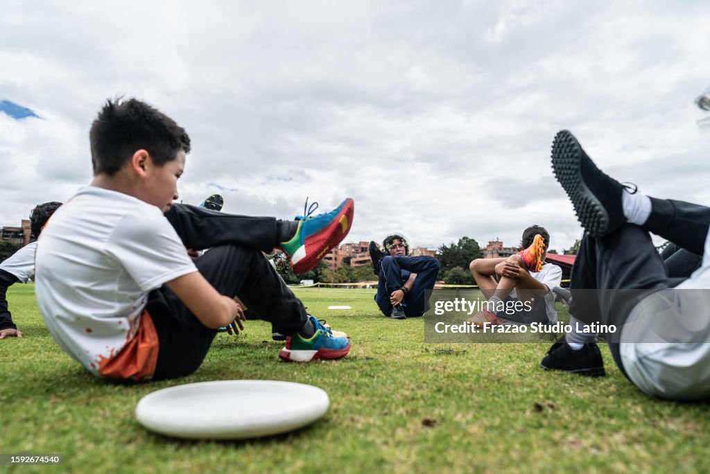 Children's team stretching before training on the sports field
