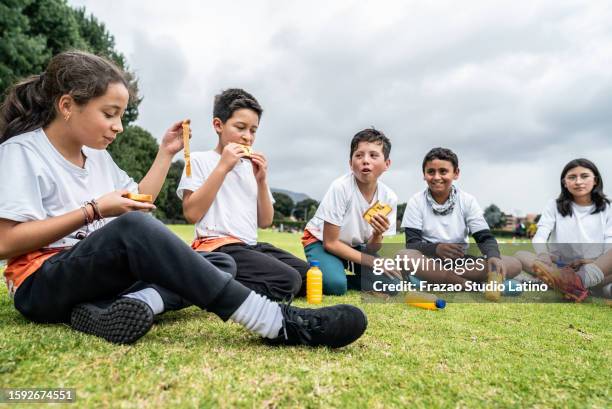 children's team taking a break after training on the sports field - school meal stock pictures, royalty-free photos & images