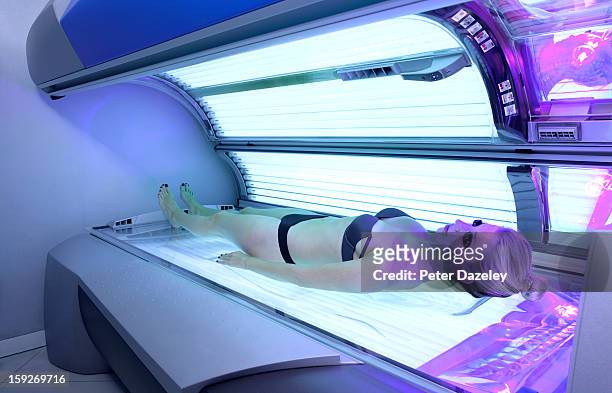 young woman laying on sunbed - tanning bed stock pictures, royalty-free photos & images