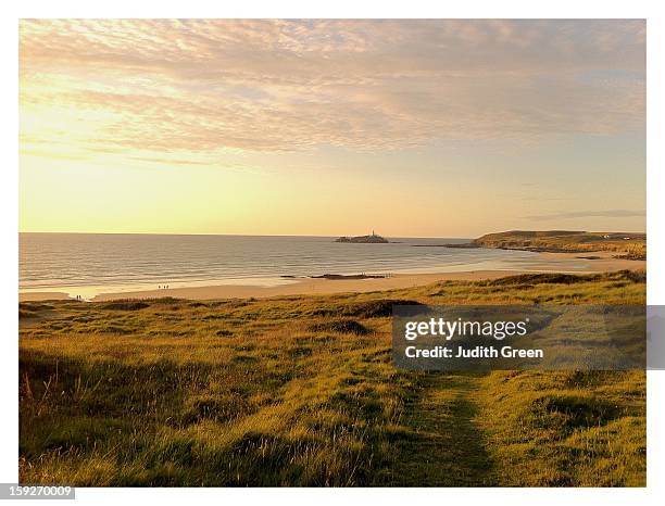 sunset over grassy headland looking out to sea - gwithian foto e immagini stock