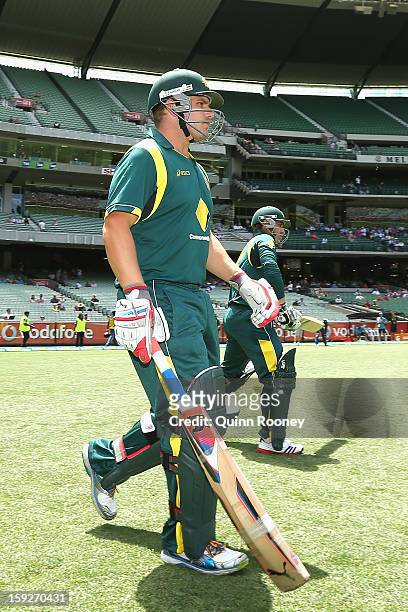 Aaron Finch and Phillip Hughes of Australia walk out to bat during game one of the Commonwealth Bank One Day International series between Australia...