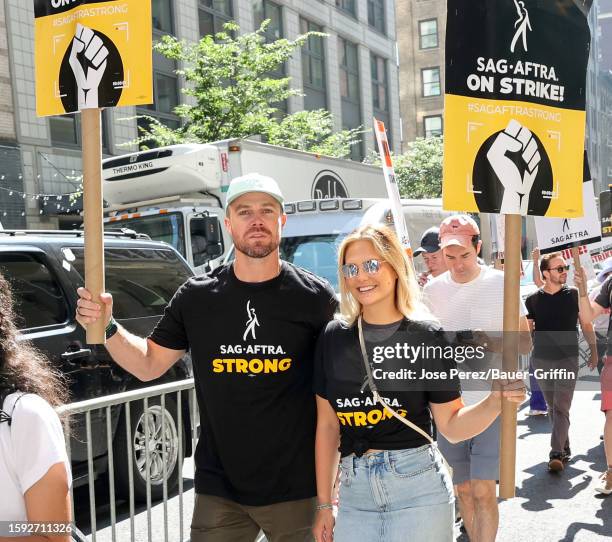 Stephen Amell and Cassandra Jean are seen walking the picket line with members of SAG-AFTRA in Downtown, Manhattan on August 11, 2023 in New York...