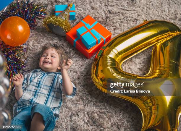 a laughing child of 4 years old plays at childrens birthday party with balloon - 4 5 years balloon stock pictures, royalty-free photos & images