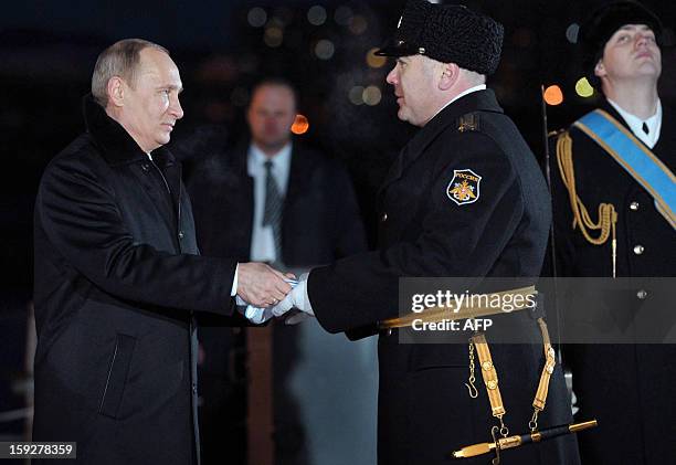 Russia's President Vladimir Putin hands over the Nakhimov medal to the Peter the Great nuclear cruiser's captain Vladislav Malakhovsky during an...