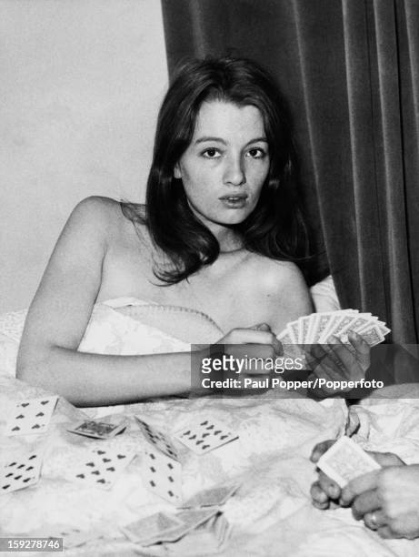 English former model and showgirl Christine Keeler, playing cards in bed at a flat belonging to her friend Paula Hamilton-Marshall in Devonshire...