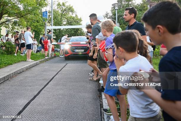 Bayern Munich fans take photos as the car with Tottenham Hotspur's English striker Harry Kane arrives at the Brothers of Charity Hospital in Munich,...