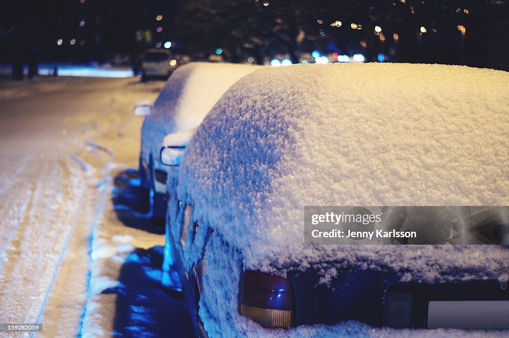 Parked cars covered in a fresh layer of snow