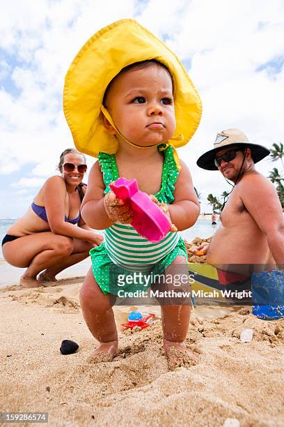 a family playing on the beach with their baby - baby sunglasses stock pictures, royalty-free photos & images