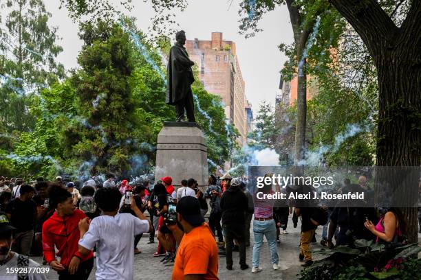 People run as a fireworks blow up as Members of the NYPD respond to the disruptions caused by large crowds during a "giveaway" event hosted by...