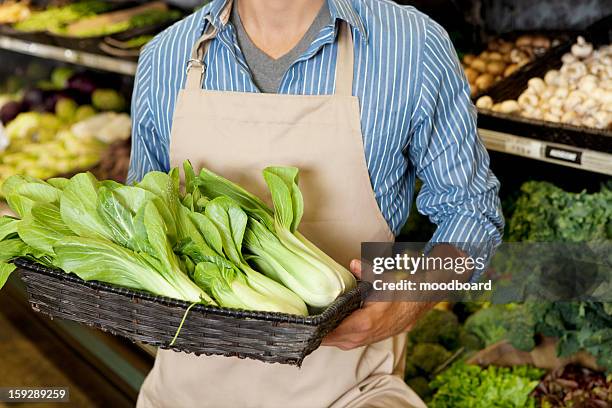 midsection of man holding basket of bok choy in supermarket - chinese cabbage imagens e fotografias de stock