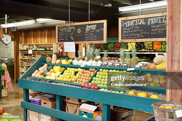 fresh fruits stall with text on blackboard in supermarket - supermarket fruit stock-fotos und bilder