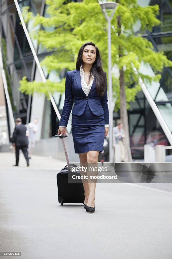 Young Indian businesswoman with luggage on business trip