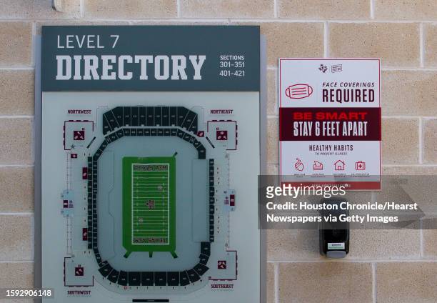 Sign reminding fans to maintain social distance and a hand sanitizing station are on the wall next to a stadium map at Kyle Field, Friday, Sept. 18...