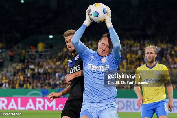 Simon Terodde of FC Schalke 04 and Goalkeeper Ron-Thorben Hoffmann of Eintracht Braunschweig battle for the ball during the DFB cup first round match...