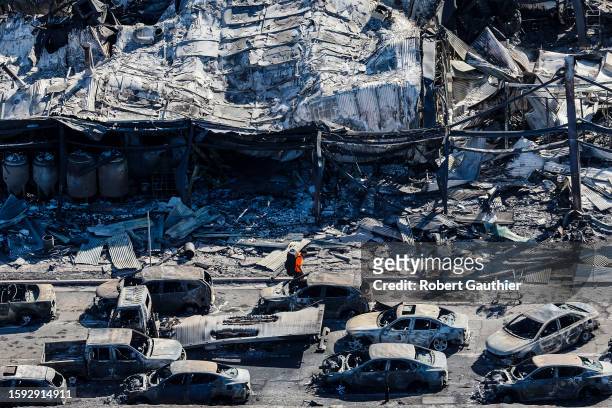 Lahaina, Maui, Thursday, August 11, 2023 - A man walks along Front Street, past the burned carcasses of cars that couldn't escape a catastrophic...