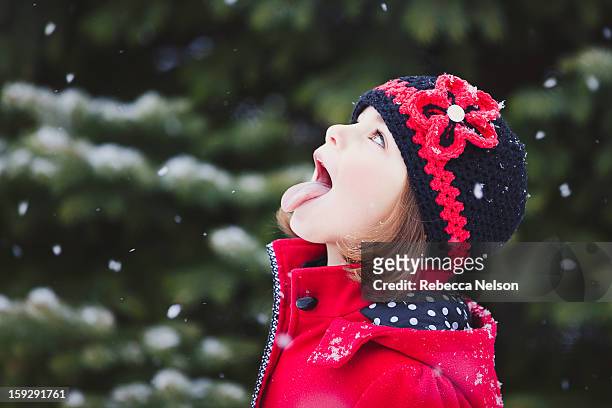little girl catching snowflakes on her tongue - tongue out stock pictures, royalty-free photos & images