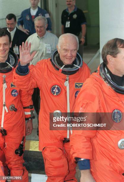 Astronaut and Senator John Glenn waves to members of the media as he leaves the crew's quarters at the Kennedy Space Center 09 October 1998, as the...