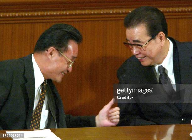 National People's Congress Chairman Li Peng gets a thumbs up from his successor Wu Bangguo after delivering his final address at the Great Hall of...