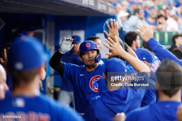 Seiya Suzuki of the Chicago Cubs celebrates in the dugout after scoring on a Mike Tauchman single in the fourth inning of their MLB game against the...