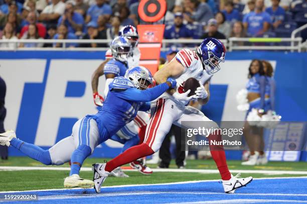 New York Giants tight end Tommy Sweeney scores a touchdown under pressure from Detroit Lions linebacker Jalen Reeves-Maybin during the first half of...