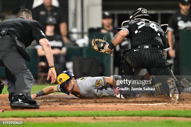 Sal Frelick of the Milwaukee Brewers slides across home plate to score a run in the fifth inning as catcher Yasmani Grandal of the Chicago White Sox...