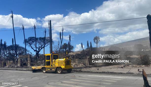 Utility vehicule is parked by destroyed buildings and homes pictured in the aftermath of a wildfire in Lahaina, western Maui, Hawaii on August 11,...