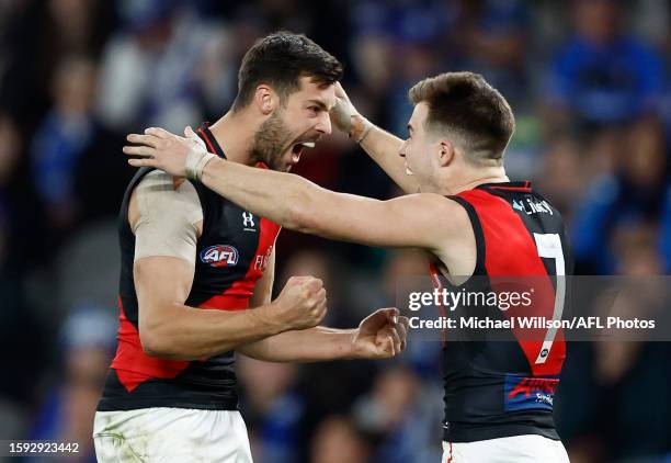 Kyle Langford and Zach Merrett of the Bombers celebrate during the 2023 AFL Round 22 match between the North Melbourne Kangaroos and the Essendon...