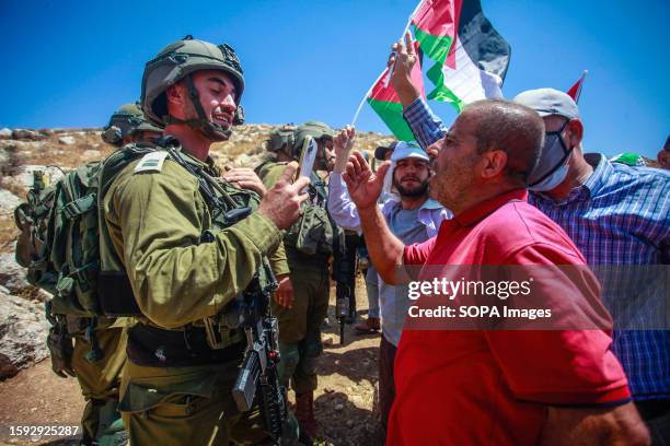 An Israeli soldier filming a Palestinian protester during a confrontation at the demonstration against Israeli settlements in the village of Beit...