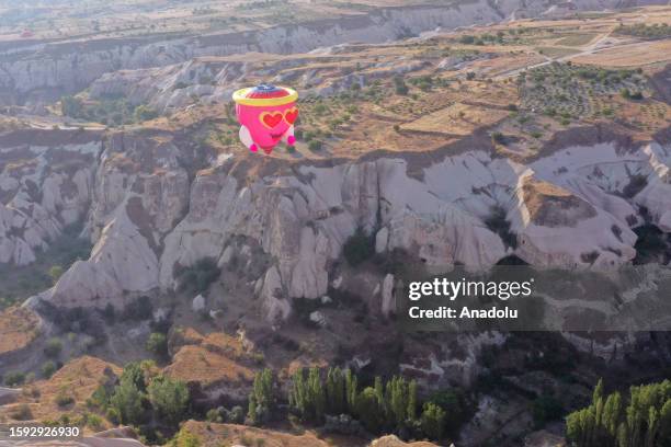 Hot air balloon glides over historical Cappadocia region during Cappadocia Balloon and Culture Festival in Nevsehir, Turkiye on August 12, 2023. Hot...