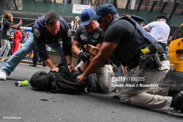 Members of the NYPD arrest people after responding to thousands of people gathered for a "giveaway" event announced by popular Twitch live streamer...