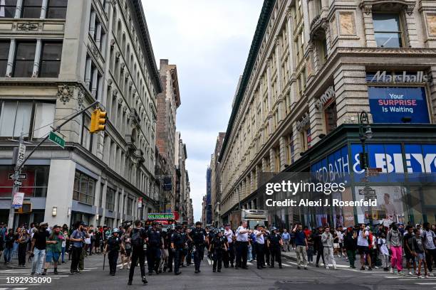 Members of the NYPD stand along 6th Avenue before pushing people to 7th avenue while responding to the disruptions caused by large crowds during a...