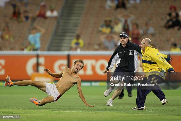 Pitch invader tries to outrun security during game one of the Commonwealth Bank One Day International series between Australia and Sri Lanka at...