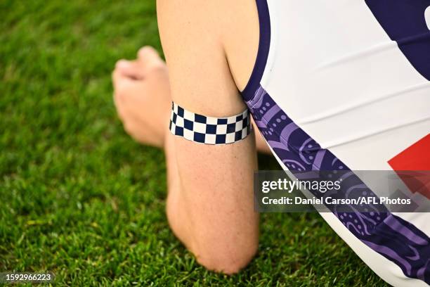 Players wear arm bands for fallen police officer Anthony Woods during the 2023 AFL Round 22 match between the West Coast Eagles and the Fremantle...