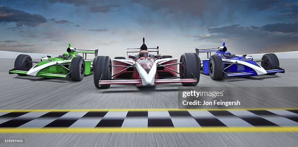 3 INDY race cars racing towards finish line.