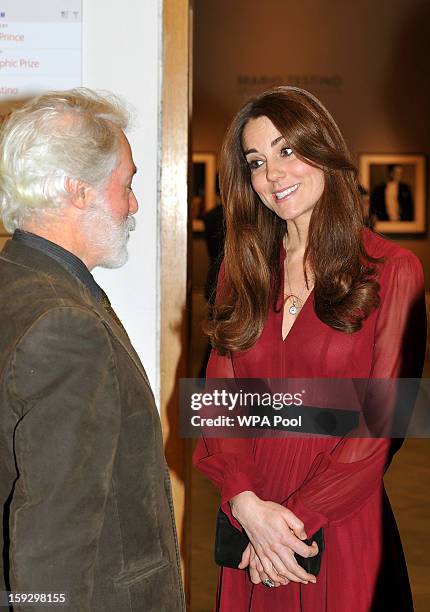 Catherine, Duchess of Cambridge is seen speaking to artist Paul Emsley after viewing his new portrait of herself during a private viewing at the...