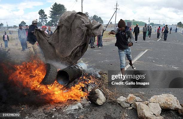 Striking farm workers set fire to tires on the N2 highway on January 10, 2013 in Grabouw, South Aifrca. Striking farm workers have blocked the...