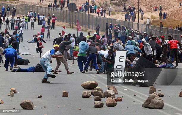 Farm workers scatter as police fire rubber bullets to stop them making barricades to block off the N2 on January 10, 2013 in Grabouw, South Africa....