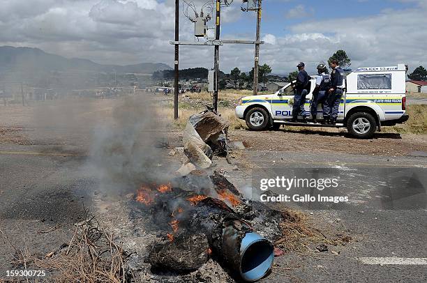 Members of the SAPS on the N2 highway on January 10, 2013 in Grabouw, South Aifrca. Striking farm workers have blocked the highway as they continue...