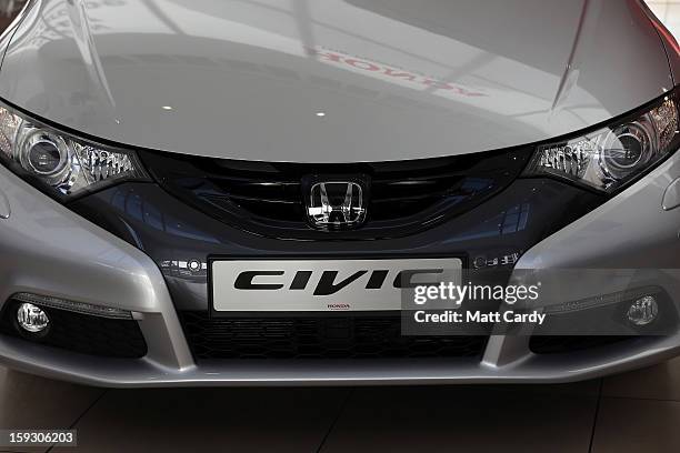 The Honda logo is seen on a Honda Civic displayed in the reception of a office building at the Honda car assembly plant following the announcement...